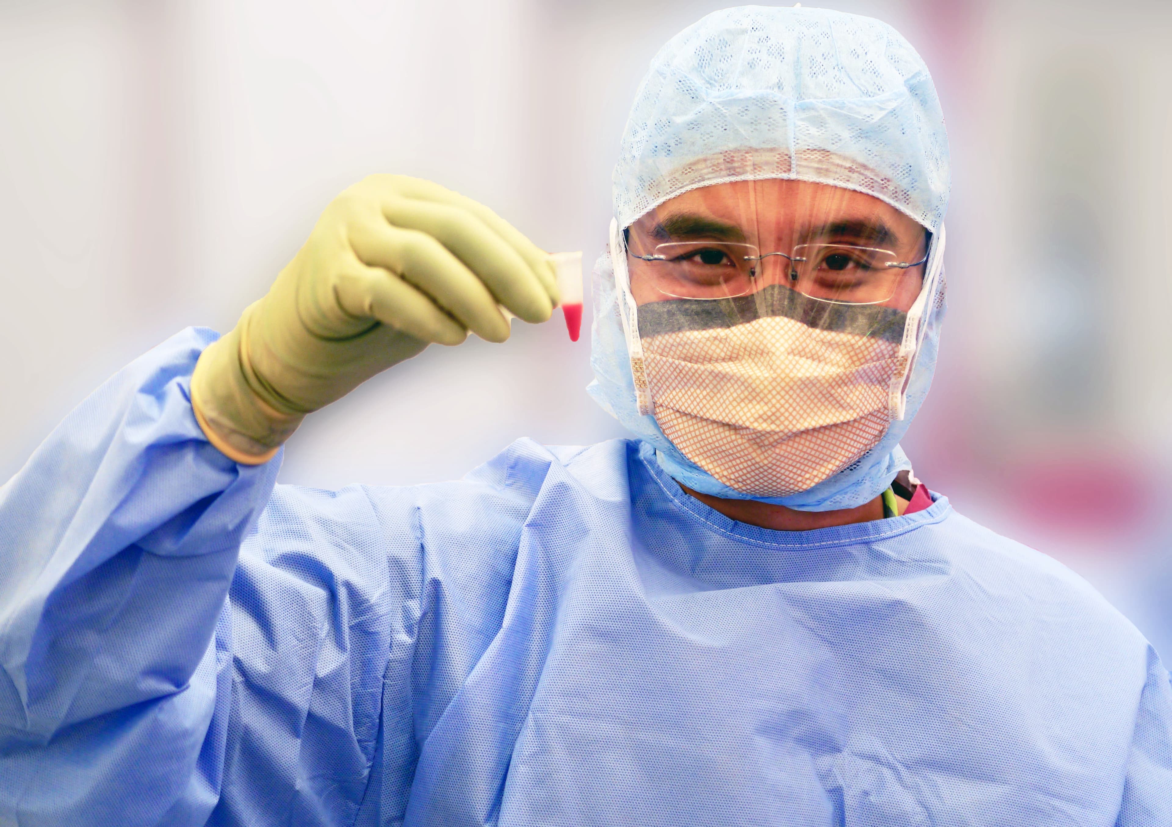 Professor Lee in surgical attire with biological specimen
